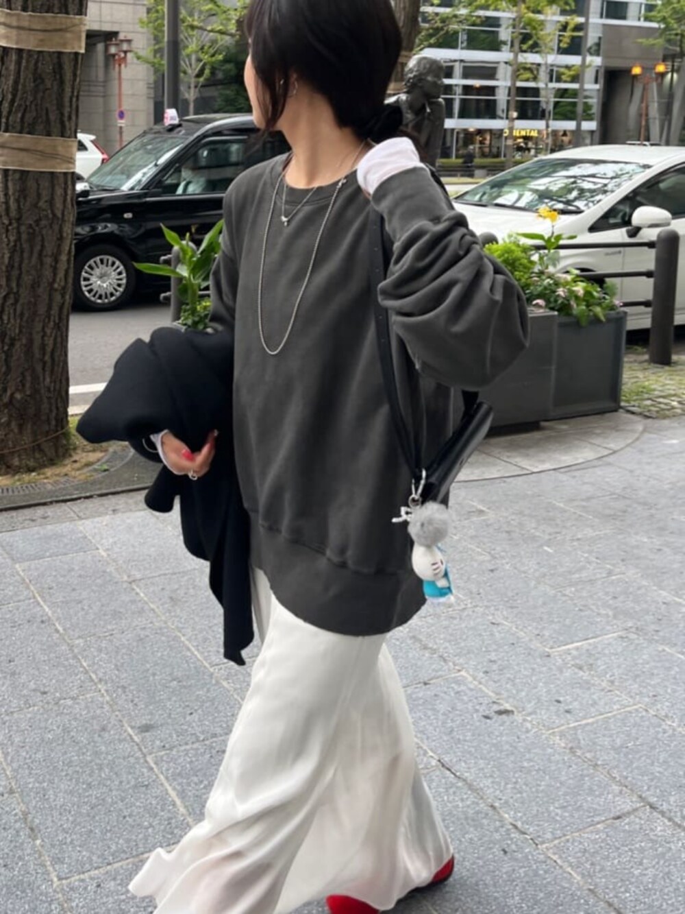 グレー系のTシャツ/カットソー、ホワイト系のスカート、ホワイト系のTシャツ/カットソーを着用したレディースの秋コーディネートの3枚目の写真