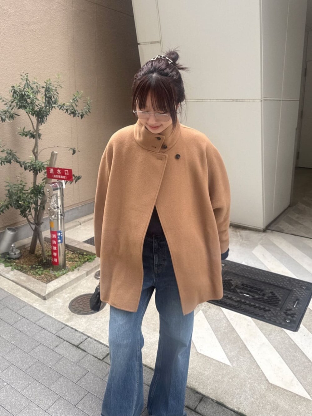 ブルー系のデニムパンツ、ブルー系のニット/セーター、イエロー系のその他アウターを着用したレディースの秋コーディネートの3枚目の写真