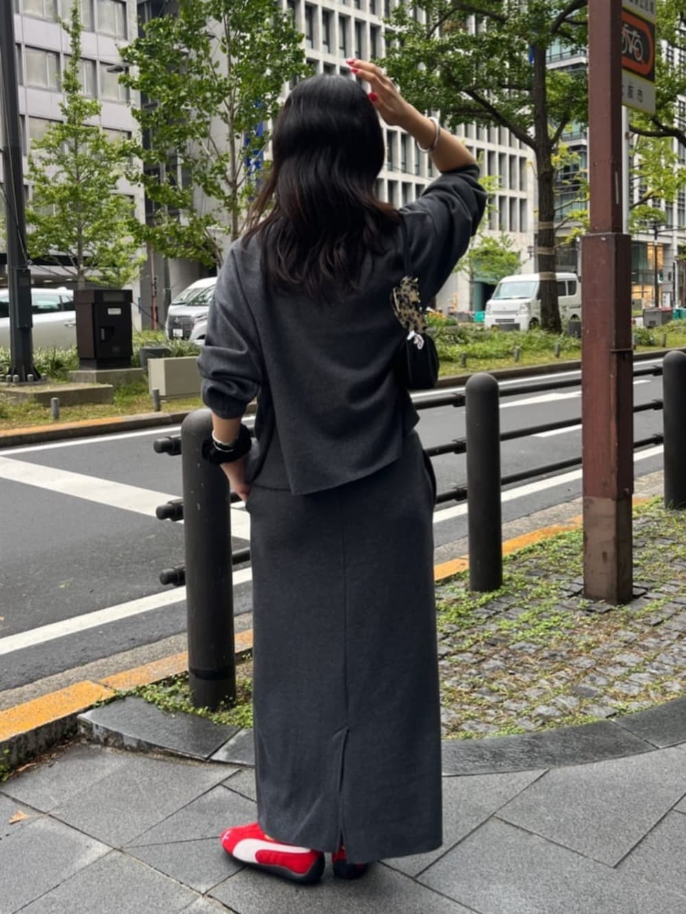 グレー系のスカート、グレー系のTシャツ/カットソー、レッド系のスニーカーを着用したレディースの秋コーディネートの3枚目の写真