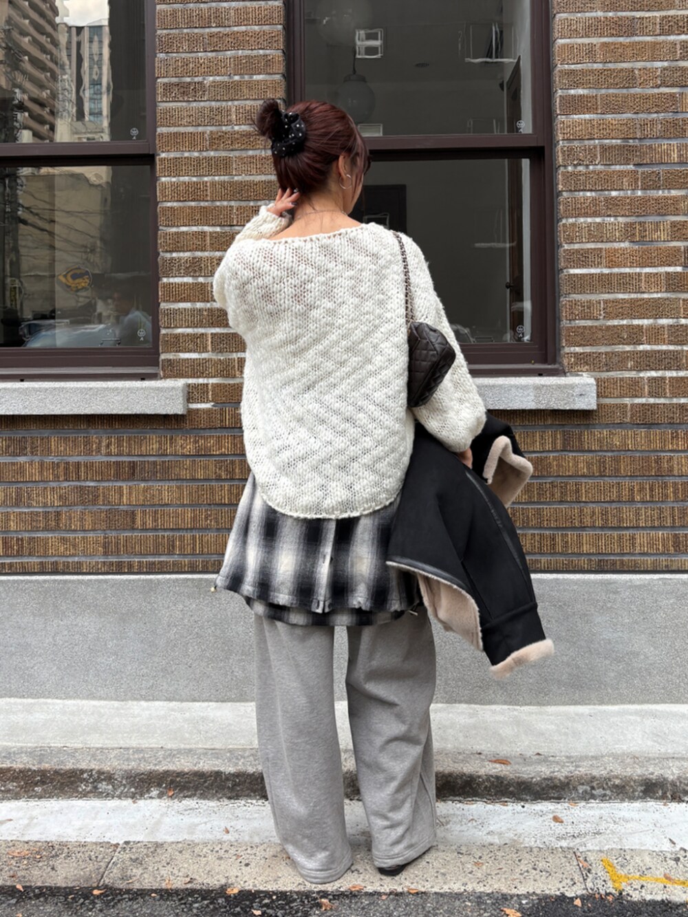 グレー系のその他パンツ、ブラック系のシャツ/ブラウス、ホワイト系のニット/セーターを着用したレディースの冬コーディネートの3枚目の写真