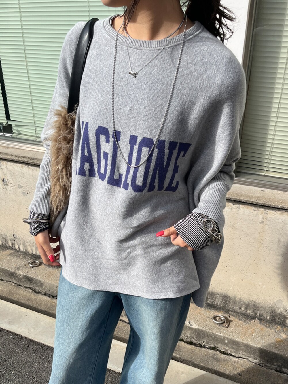 ブルー系のデニムパンツ、ホワイト系のTシャツ/カットソー、グレー系のニット/セーターを着用したレディースの秋コーディネートの4枚目の写真