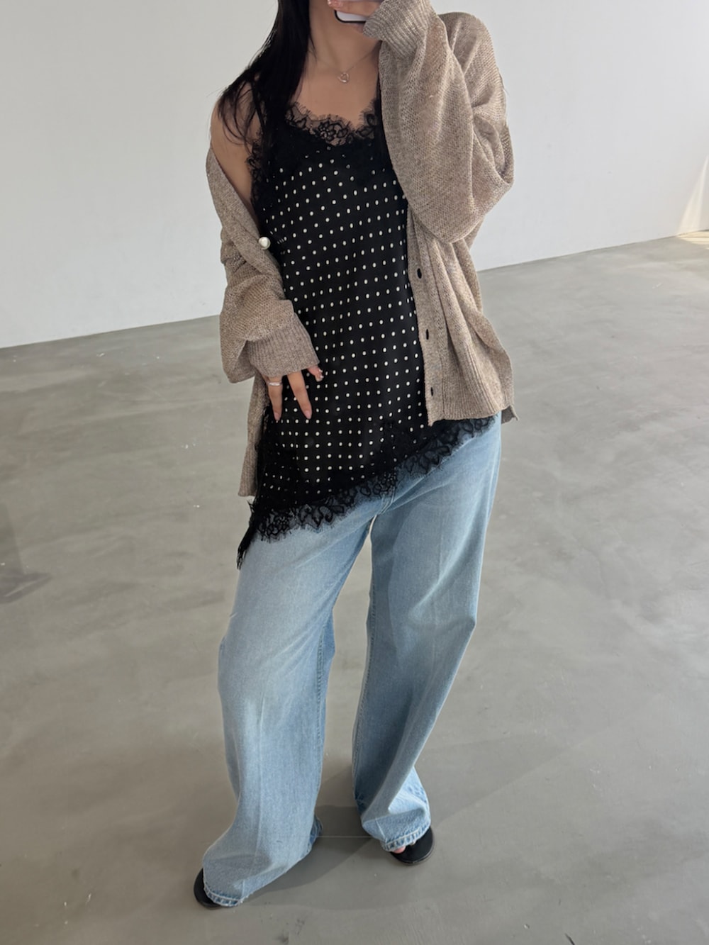 ブルー系のデニムパンツ、ブラック系のシャツ/ブラウス、ベージュ系のカーディガン/ボレロを着用したレディースの春コーディネートの3枚目の写真