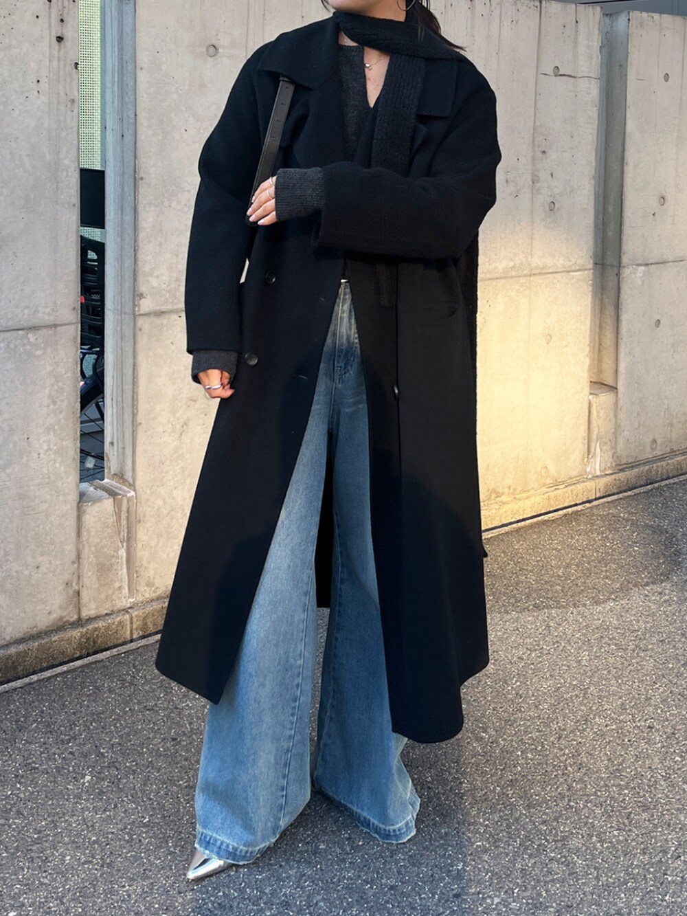 ブルー系のデニムパンツ、ブラック系のその他アウター、グレー系のニット/セーターを着用したレディースの秋コーディネートの2枚目の写真