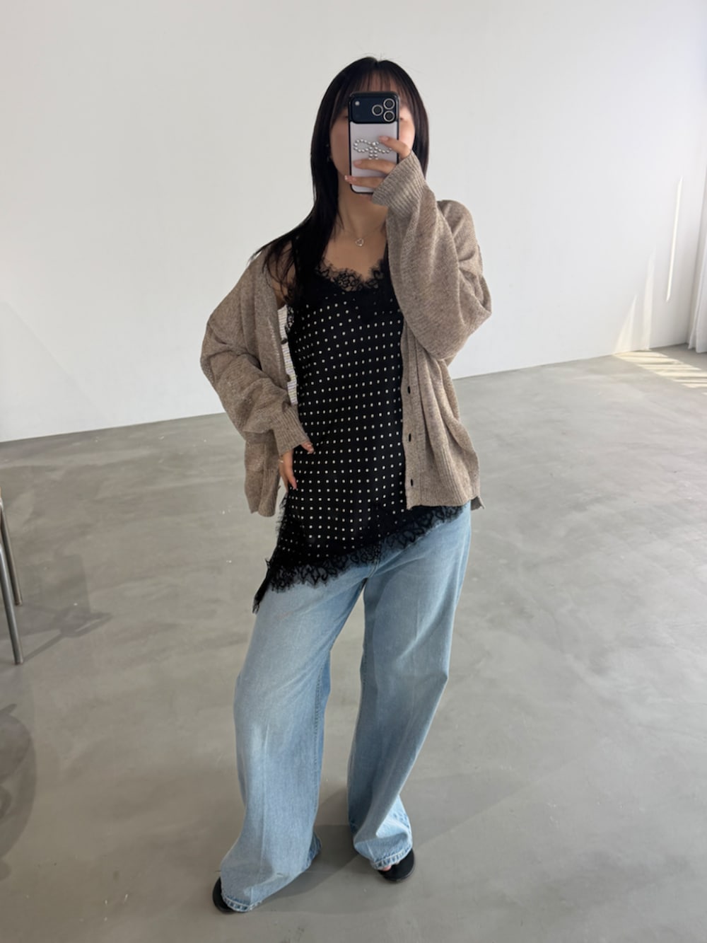 ブルー系のデニムパンツ、ブラック系のシャツ/ブラウス、ベージュ系のカーディガン/ボレロを着用したレディースの春コーディネートの2枚目の写真