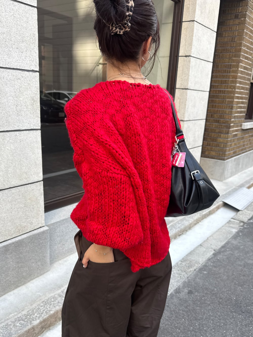 レッド系のニット/セーター、ブラウン系のその他パンツを着用したレディースの秋コーディネートの3枚目の写真