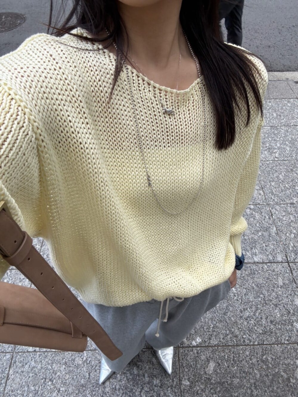 グレー系のその他パンツ、イエロー系のニット/セーターを着用したレディースの春コーディネートの5枚目の写真