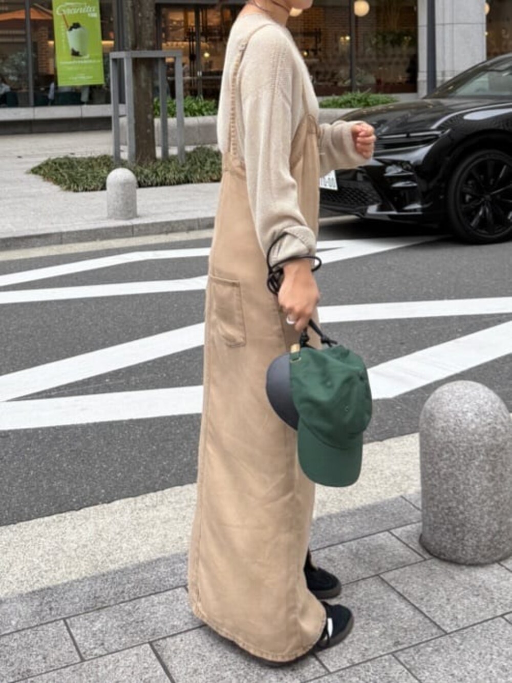 ブラック系のショルダーバッグ、ベージュ系のワンピース、ベージュ系のニット/セーターを着用したレディースの春コーディネートの3枚目の写真