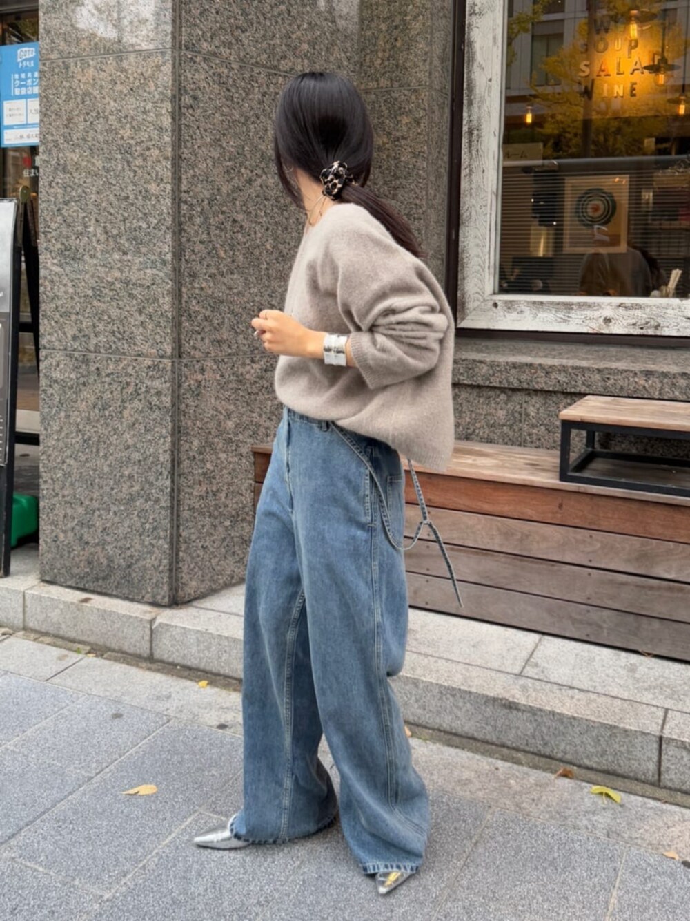 ブルー系のデニムパンツ、ブラウン系のニット/セーターを着用したレディースの冬コーディネートの2枚目の写真