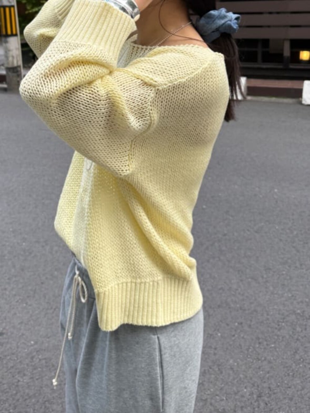 グレー系のその他パンツ、イエロー系のニット/セーターを着用したレディースの春コーディネートの3枚目の写真