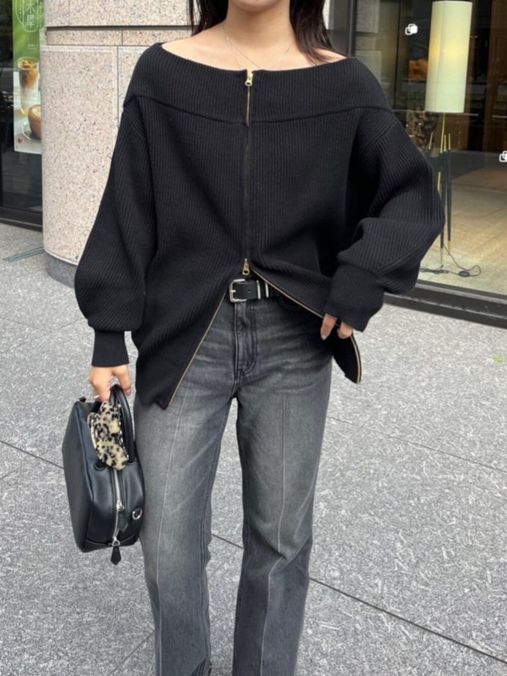 ブラック系のデニムパンツ、ブラック系のニット/セーター、ブラック系のショルダーバッグを着用したレディースの秋コーディネートの5枚目の写真