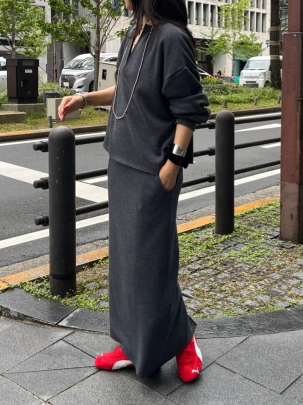 グレー系のスカート、グレー系のTシャツ/カットソー、レッド系のスニーカーを着用したレディースの秋コーディネートの2枚目の写真