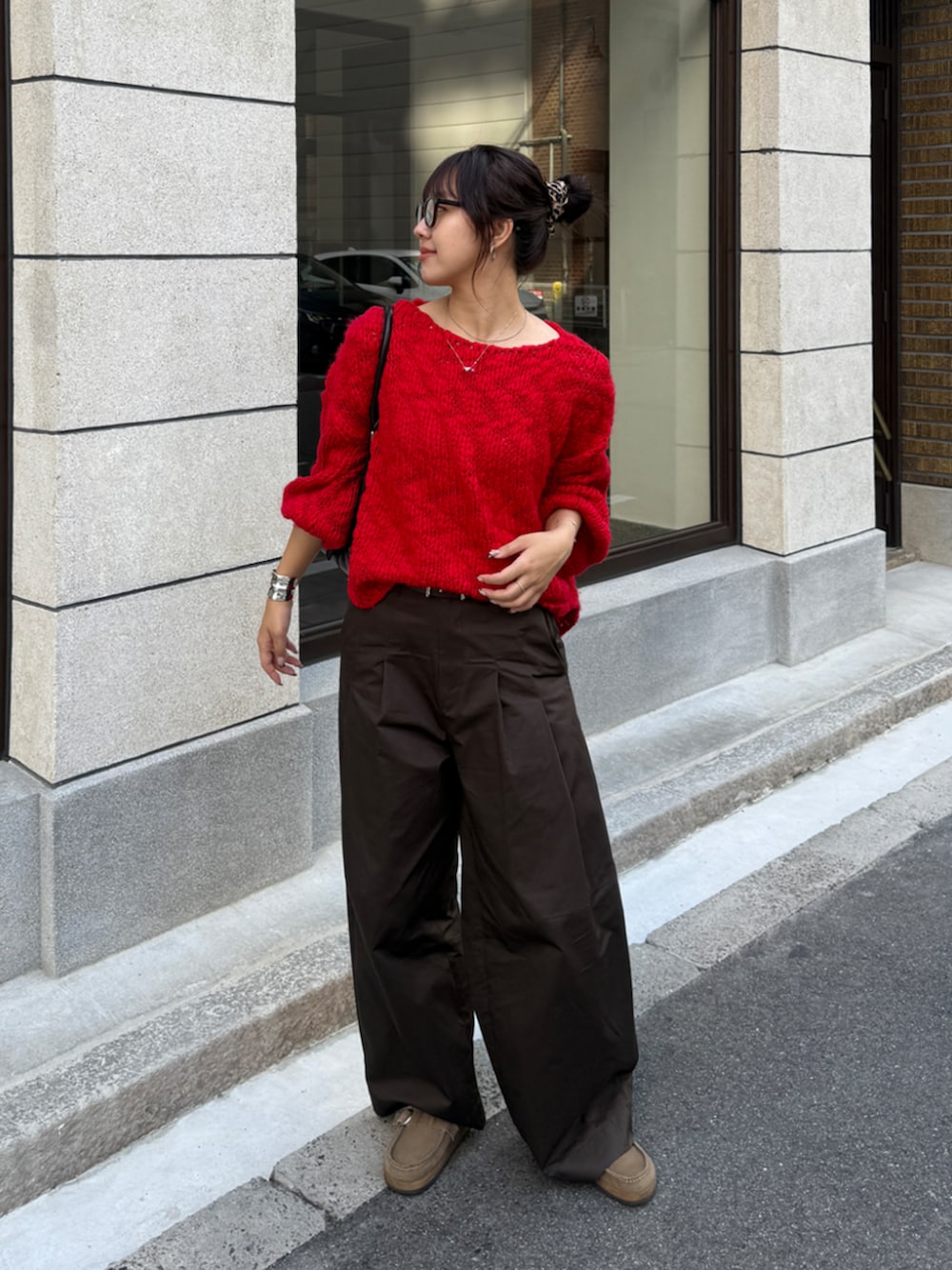 レッド系のニット/セーター、ブラウン系のその他パンツを着用したレディースの秋コーディネートの2枚目の写真