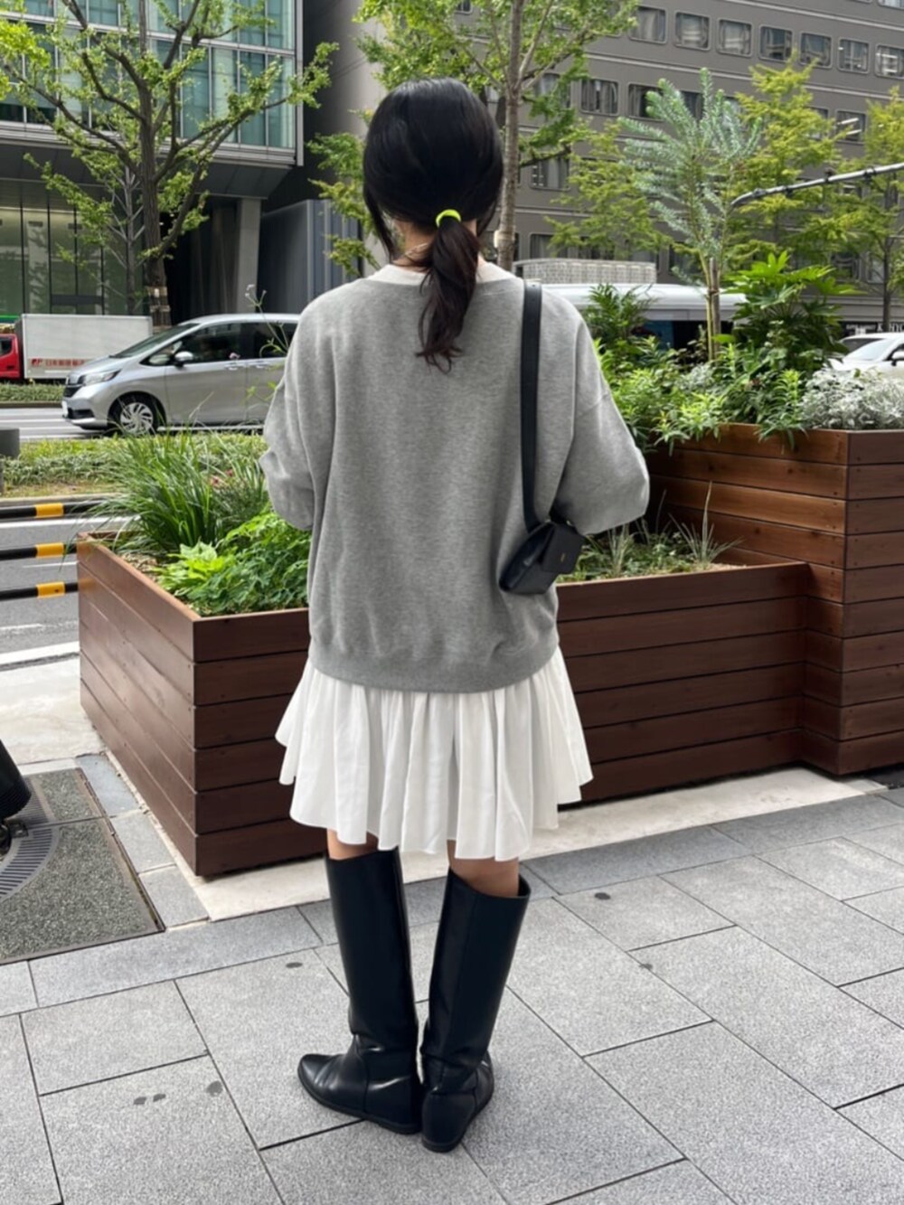 グレー系のスウェット、ホワイト系のシャツ/ブラウス、ブラック系のブーツを着用したレディースの秋コーディネートの3枚目の写真