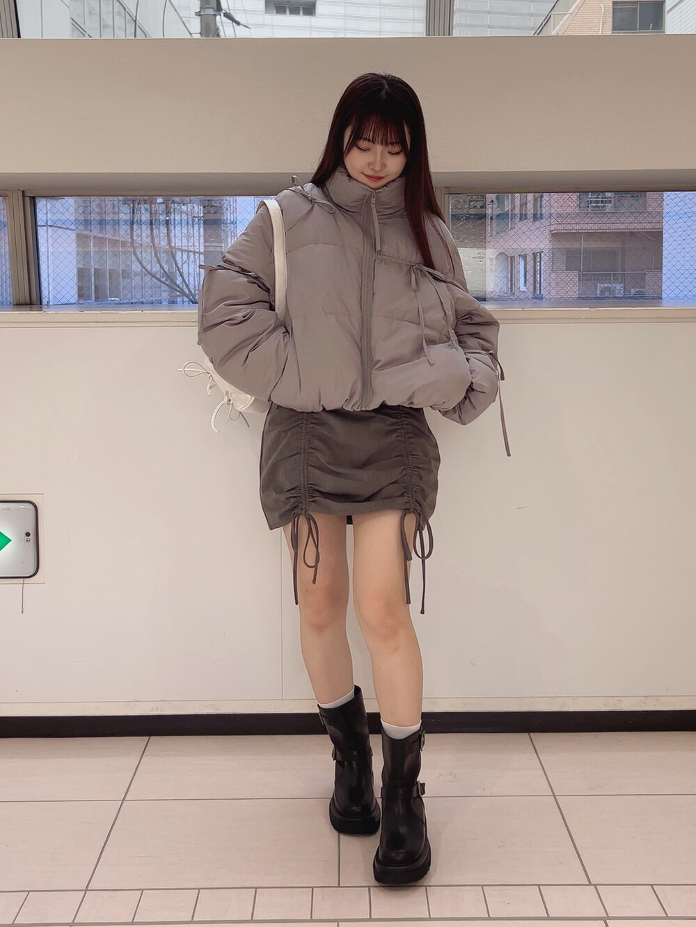 グレー系のダウンジャケット/コート、ホワイト系のTシャツ/カットソー、グレー系のスカートを着用したレディースの夏コーディネートの2枚目の写真