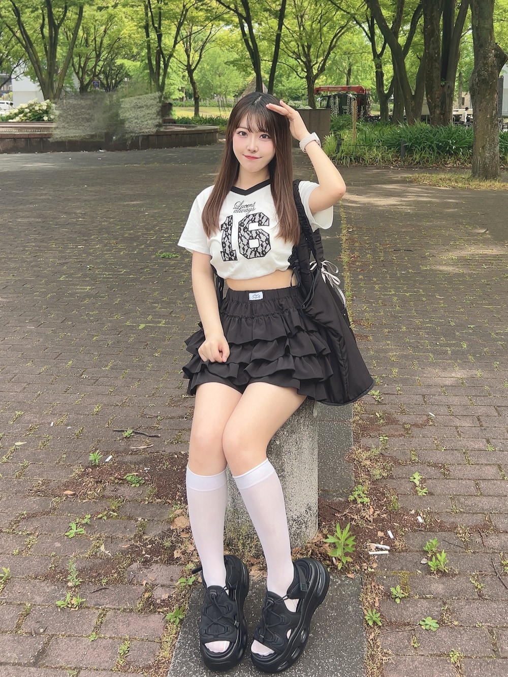 ホワイト系のTシャツ/カットソー、ブラック系のスカート、ブラック系のサンダルを着用したレディースの夏コーディネートの3枚目の写真