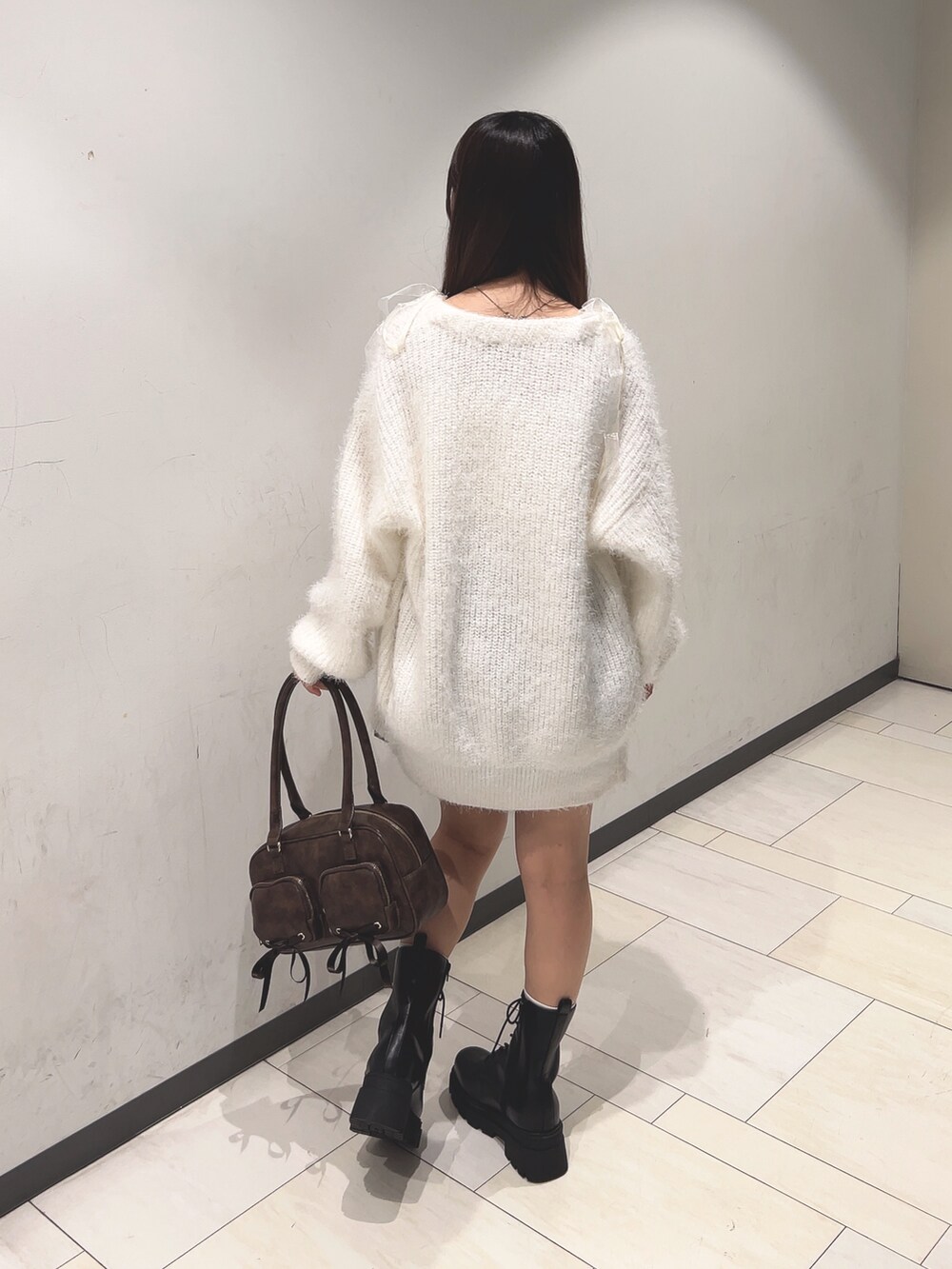 ホワイト系のアンサンブル、ホワイト系のカーディガン/ボレロ、ブラウン系のスカートを着用したレディースの秋コーディネートの3枚目の写真