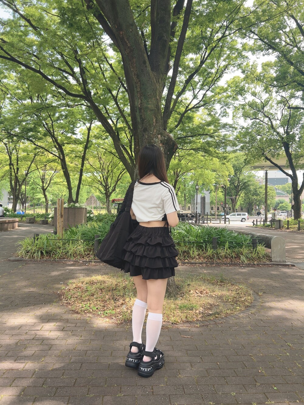 ホワイト系のTシャツ/カットソー、ブラック系のスカート、ブラック系のサンダルを着用したレディースの夏コーディネートの5枚目の写真