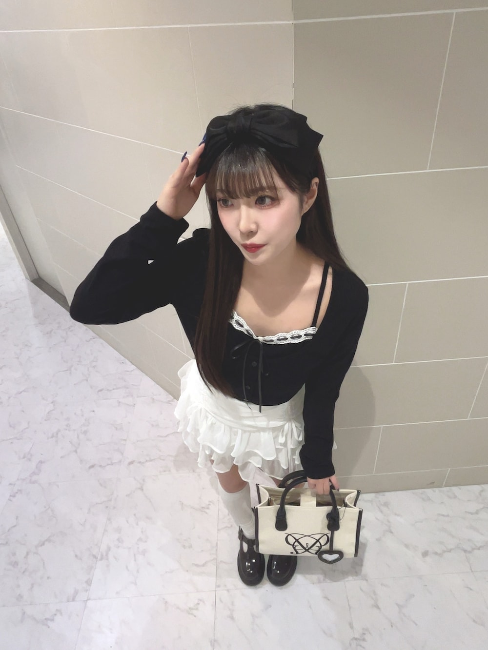ブラック系のTシャツ/カットソー、ホワイト系のスカート、ホワイト系のトートバッグを着用したレディースの春コーディネートの4枚目の写真