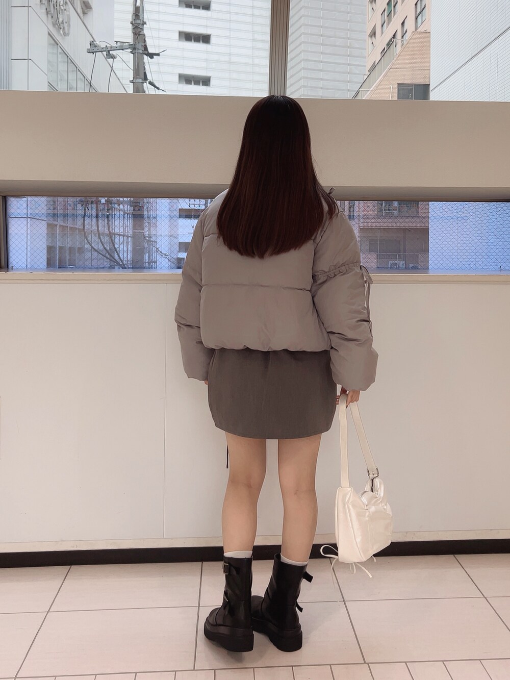 グレー系のダウンジャケット/コート、ホワイト系のTシャツ/カットソー、グレー系のスカートを着用したレディースの夏コーディネートの3枚目の写真