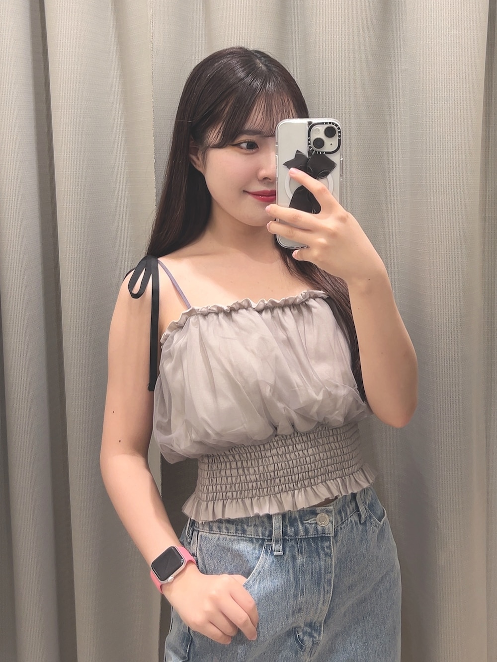 グレー系のキャミソール、ブルー系のデニムパンツ、ブラック系のサンダルを着用したレディースの夏コーディネートの3枚目の写真