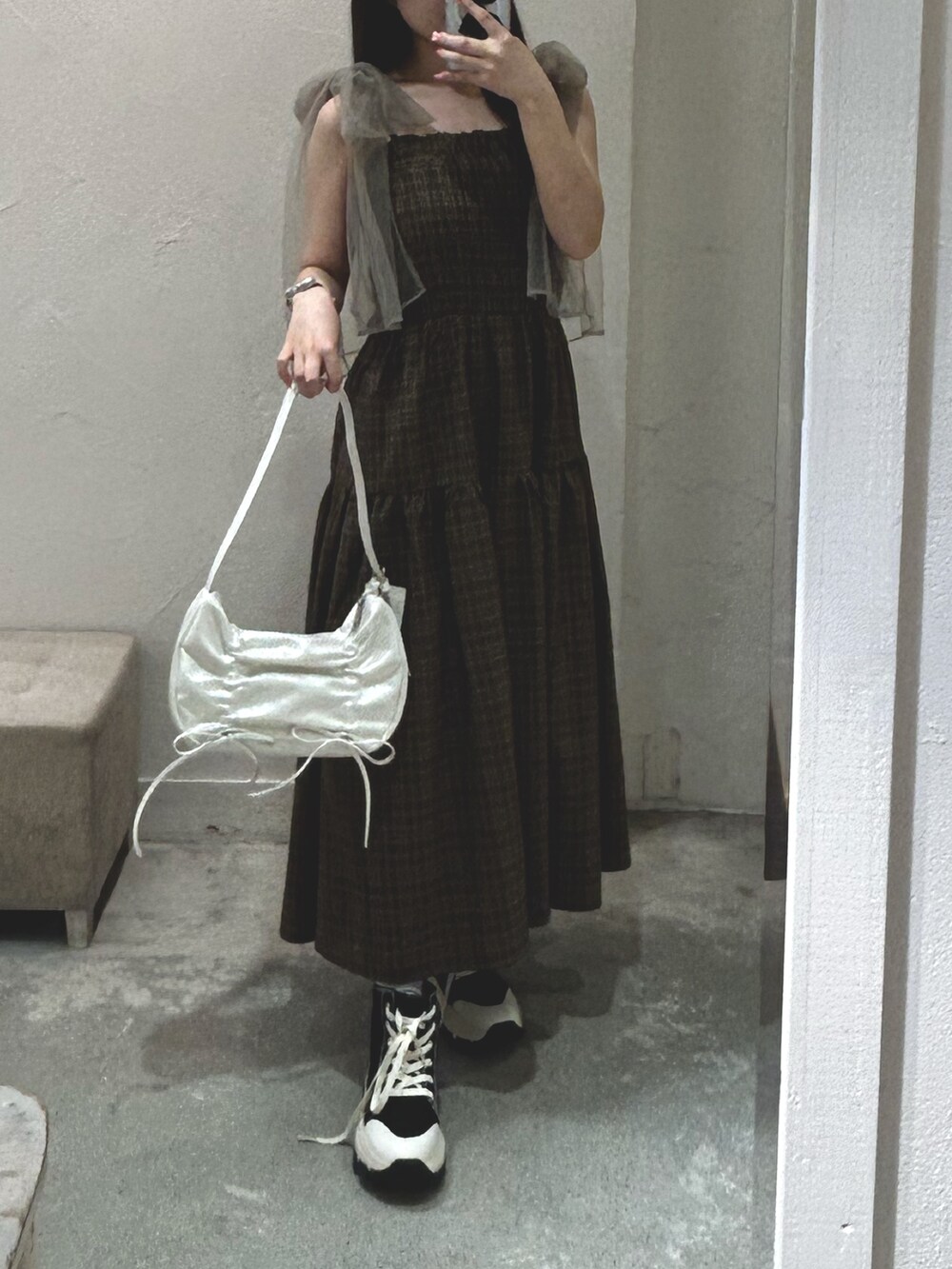 ブラウン系のワンピース、ホワイト系のショルダーバッグ、ブラック系のスニーカーを着用したレディースの夏コーディネートの3枚目の写真