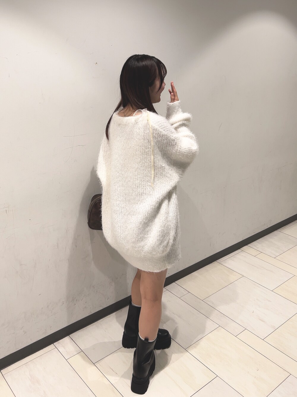 ホワイト系のアンサンブル、ホワイト系のカーディガン/ボレロ、ブラウン系のスカートを着用したレディースの秋コーディネートの2枚目の写真