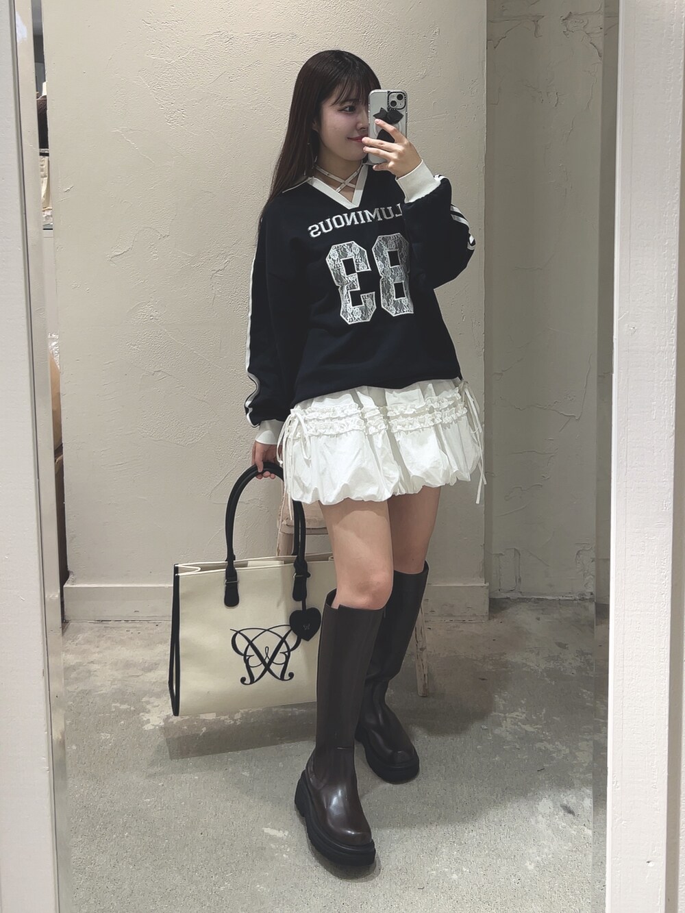 ブルー系のTシャツ/カットソー、ホワイト系のスカート、ブラウン系のその他シューズを着用したレディースの冬コーディネートの3枚目の写真