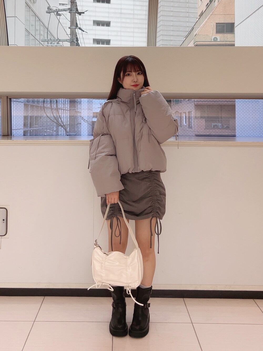 グレー系のダウンジャケット/コート、ホワイト系のTシャツ/カットソー、グレー系のスカートを着用したレディースの夏コーディネートの6枚目の写真