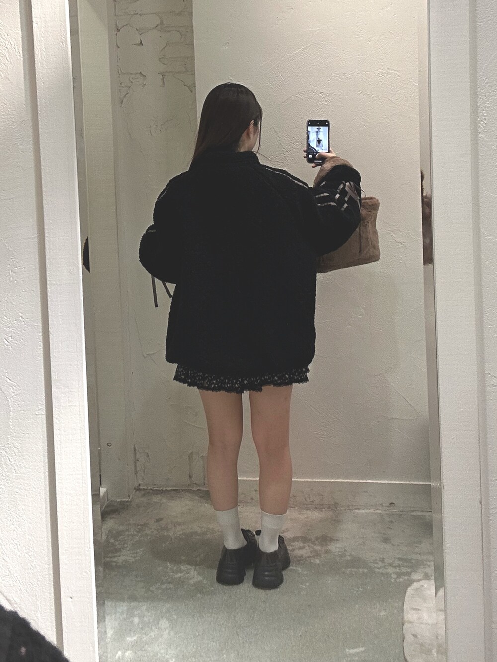 ブラック系のブルゾン、ブラウン系のトートバッグ、その他のスカートを着用したレディースの冬コーディネートの2枚目の写真