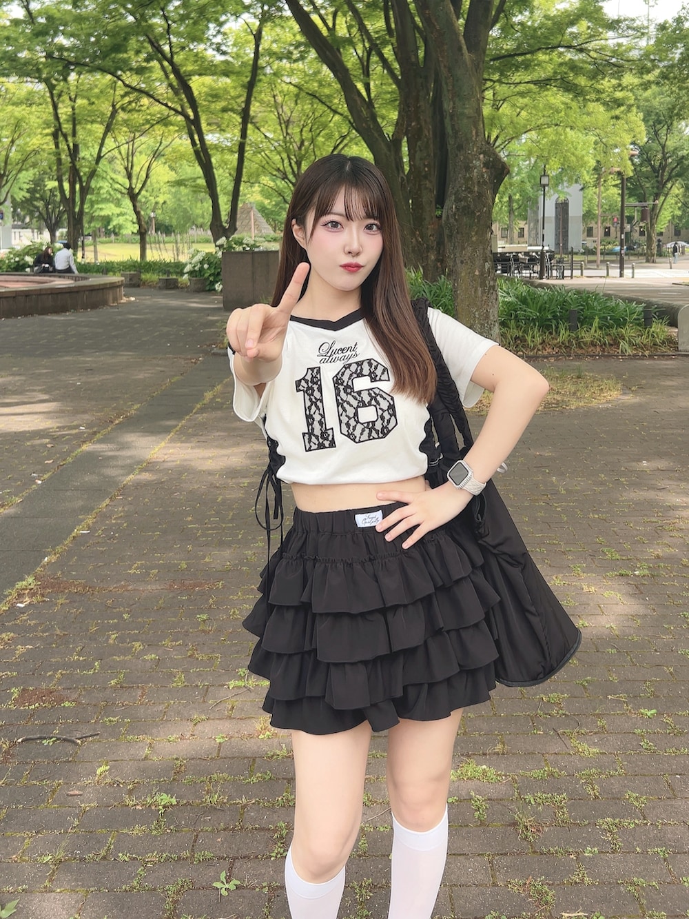 ホワイト系のTシャツ/カットソー、ブラック系のスカート、ブラック系のサンダルを着用したレディースの夏コーディネートの6枚目の写真