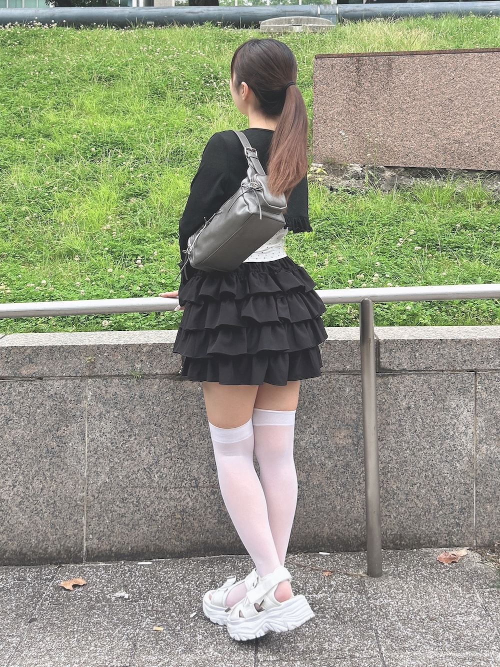 ブラック系のカーディガン/ボレロ、ブラック系のスカート、ホワイト系のサンダルを着用したレディースの夏コーディネートの2枚目の写真