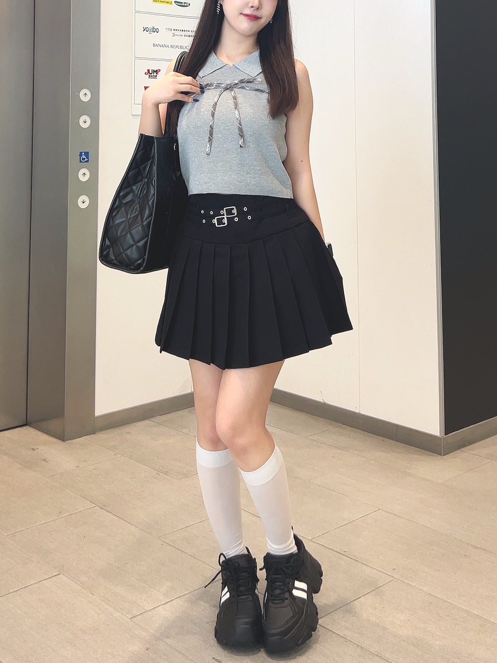 グレー系のニット/セーター、ブラック系のスカート、ブラック系のその他シューズを着用したレディースの夏コーディネートの4枚目の写真