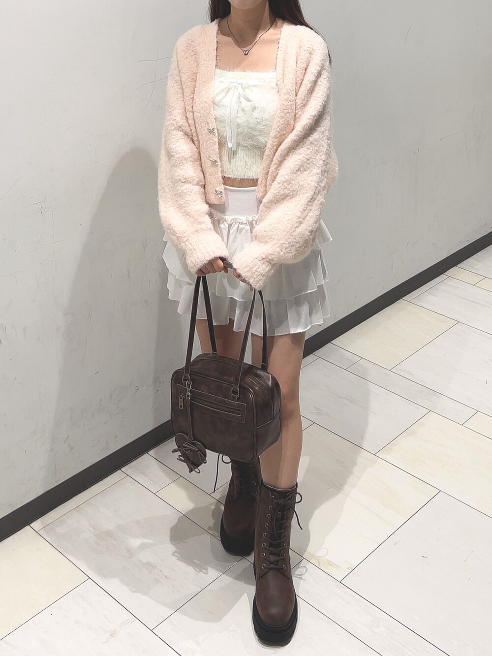ピンク系のカーディガン/ボレロ、ホワイト系のアンサンブル、ホワイト系のスカートを着用したレディースの秋コーディネートの5枚目の写真