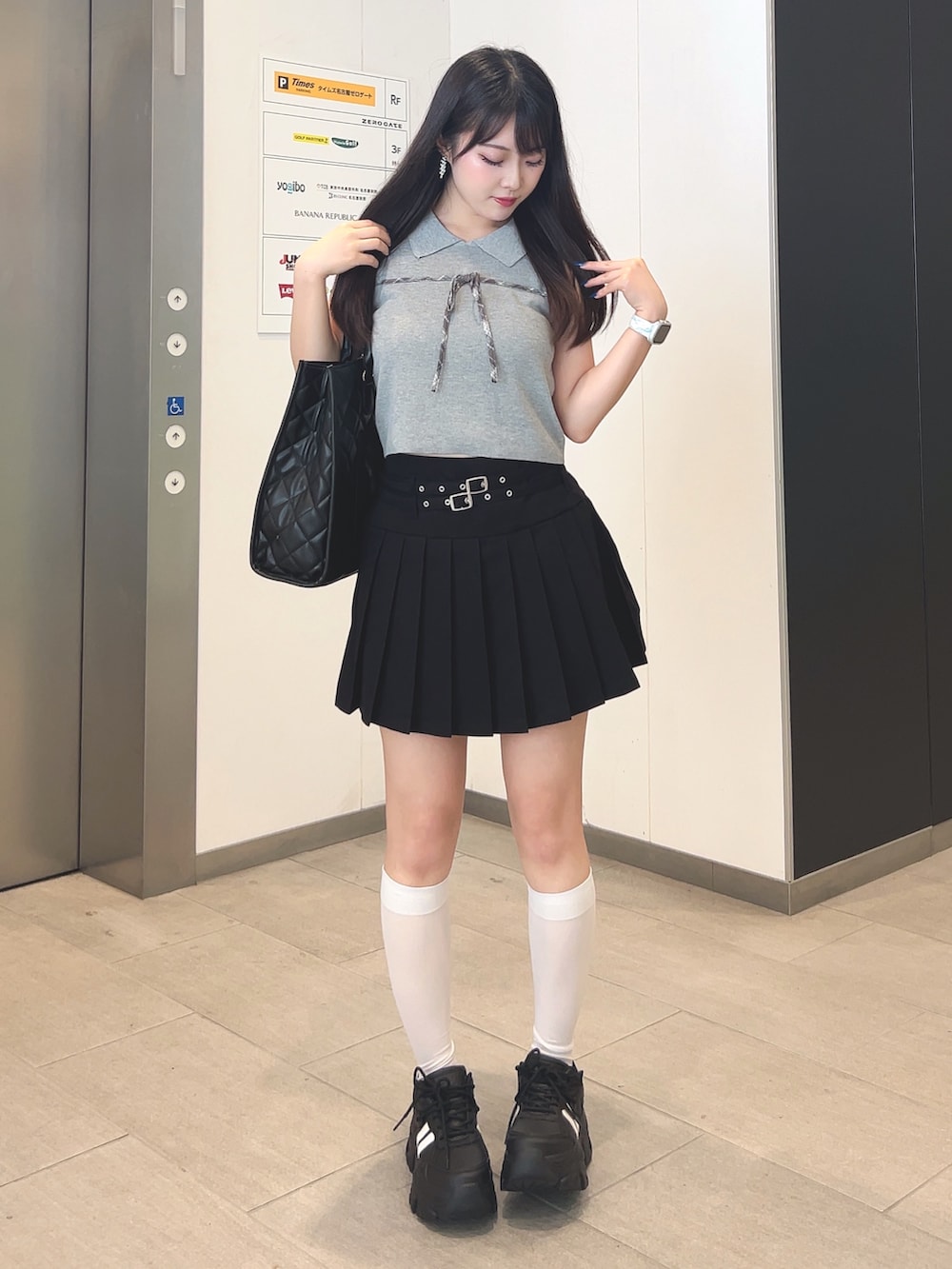 グレー系のニット/セーター、ブラック系のスカート、ブラック系のその他シューズを着用したレディースの夏コーディネートの2枚目の写真