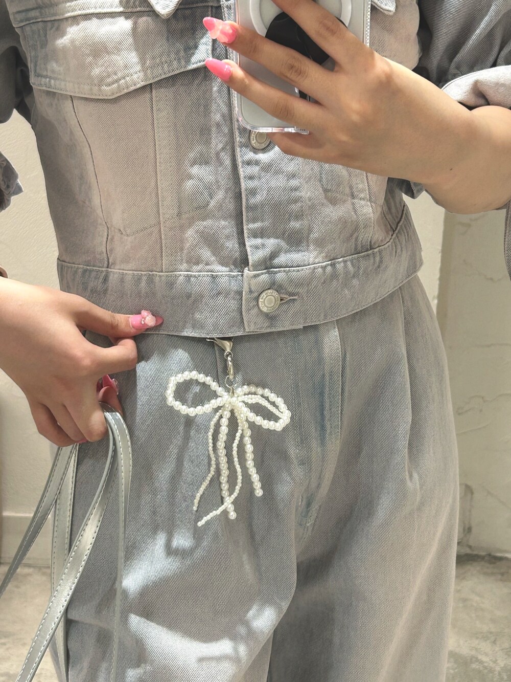 ブルー系のデニムジャケット、ブルー系のその他パンツ、シルバー系のショルダーバッグを着用したレディースの夏コーディネートの2枚目の写真