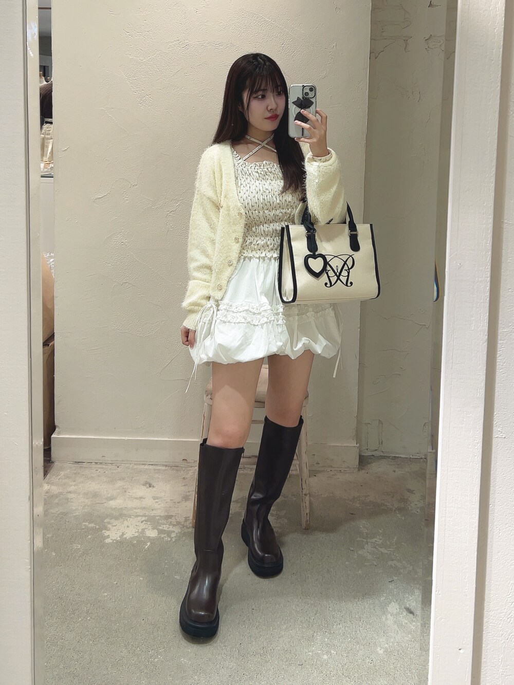 ホワイト系のTシャツ/カットソー、イエロー系のカーディガン/ボレロ、ホワイト系のトートバッグを着用したレディースの冬コーディネートの3枚目の写真