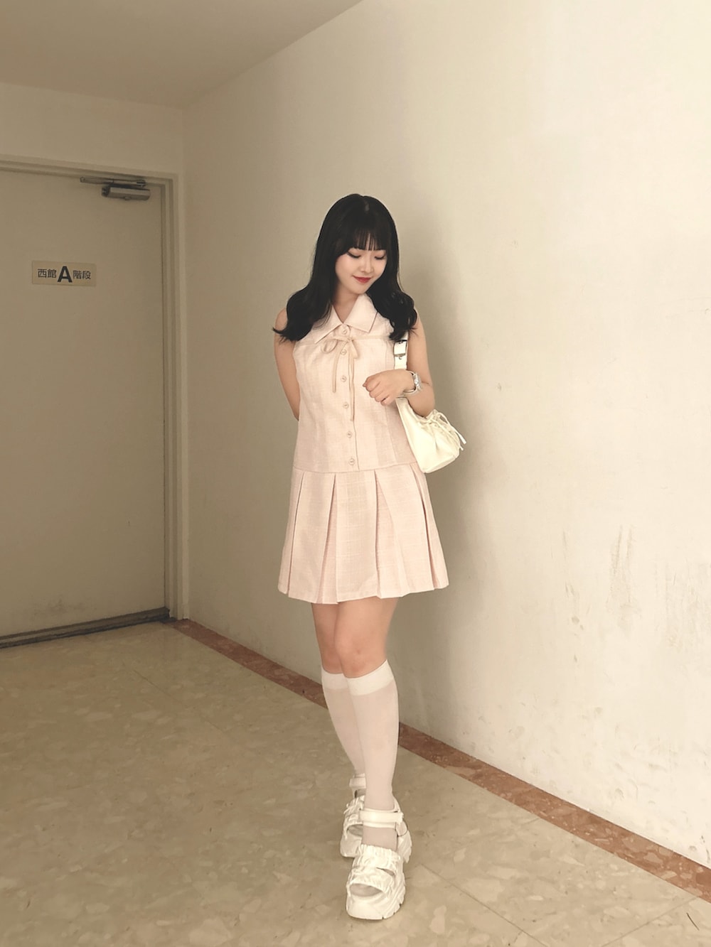 ピンク系のワンピース、ホワイト系のショルダーバッグ、ホワイト系のサンダルを着用したレディースの春コーディネートの2枚目の写真