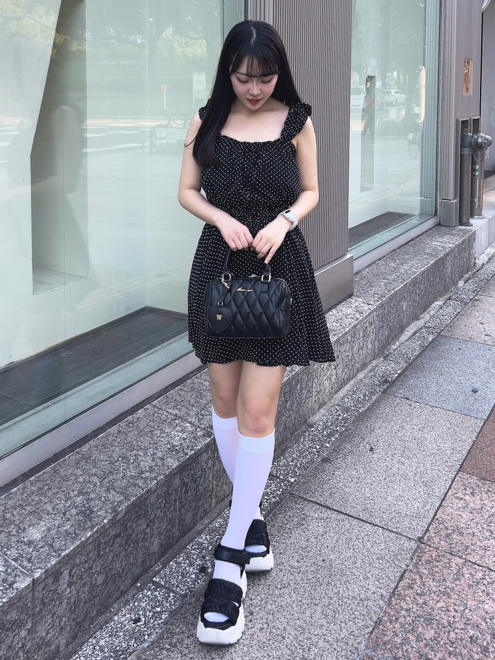 ブラック系のワンピース、ブラック系のサンダル、ブラック系のボストンバッグを着用したレディースの夏コーディネートの2枚目の写真