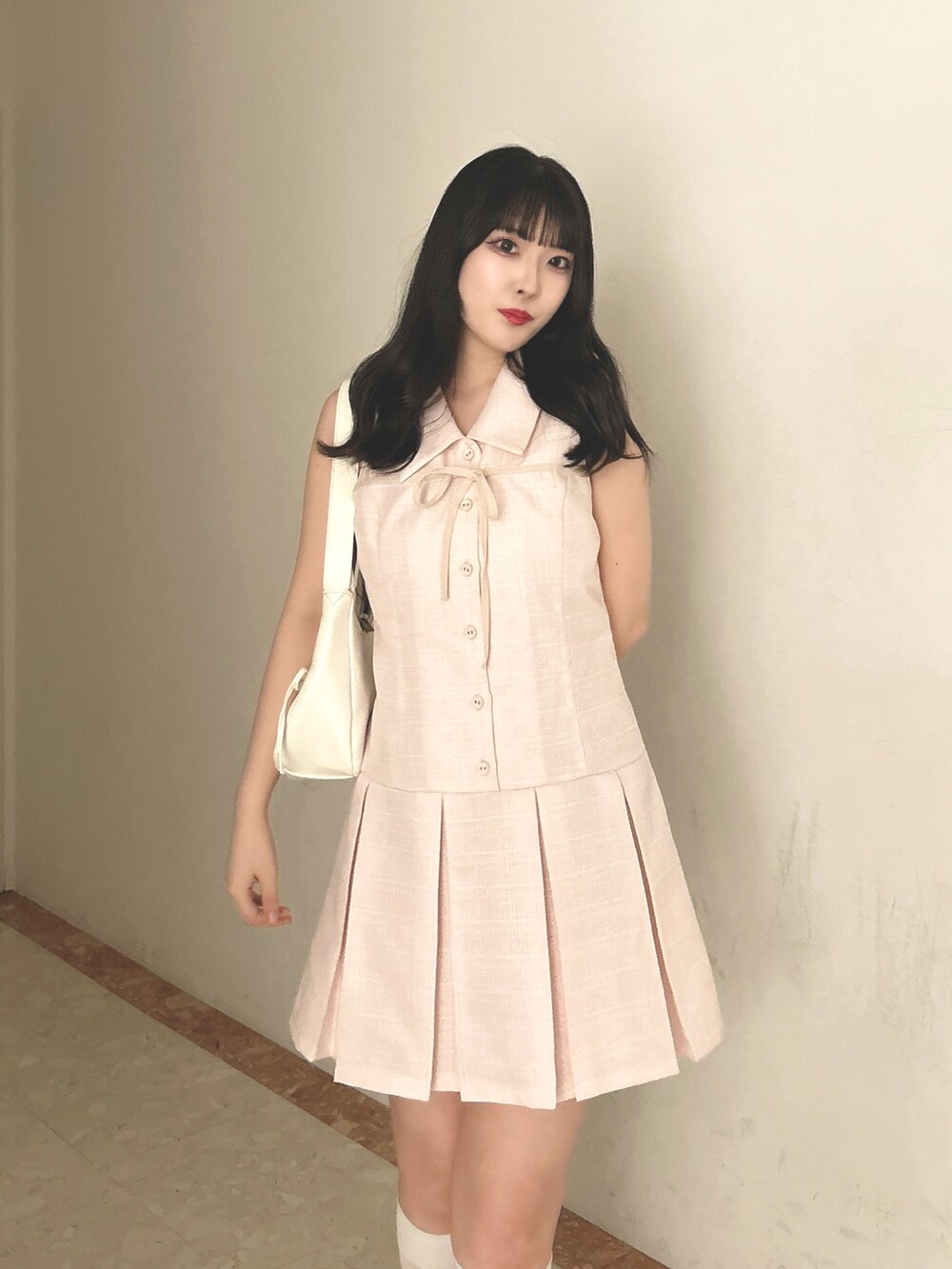 ピンク系のワンピース、ホワイト系のショルダーバッグ、ホワイト系のサンダルを着用したレディースの春コーディネートの4枚目の写真