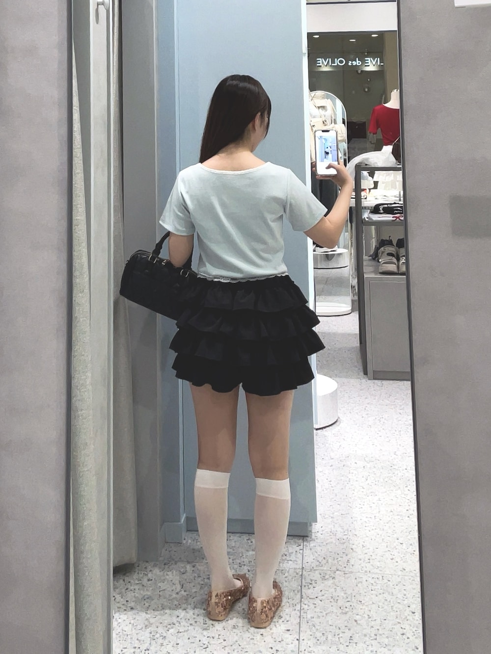 ブルー系のTシャツ/カットソー、ブラック系のスカート、ブラック系のボストンバッグを着用したレディースの夏コーディネートの2枚目の写真