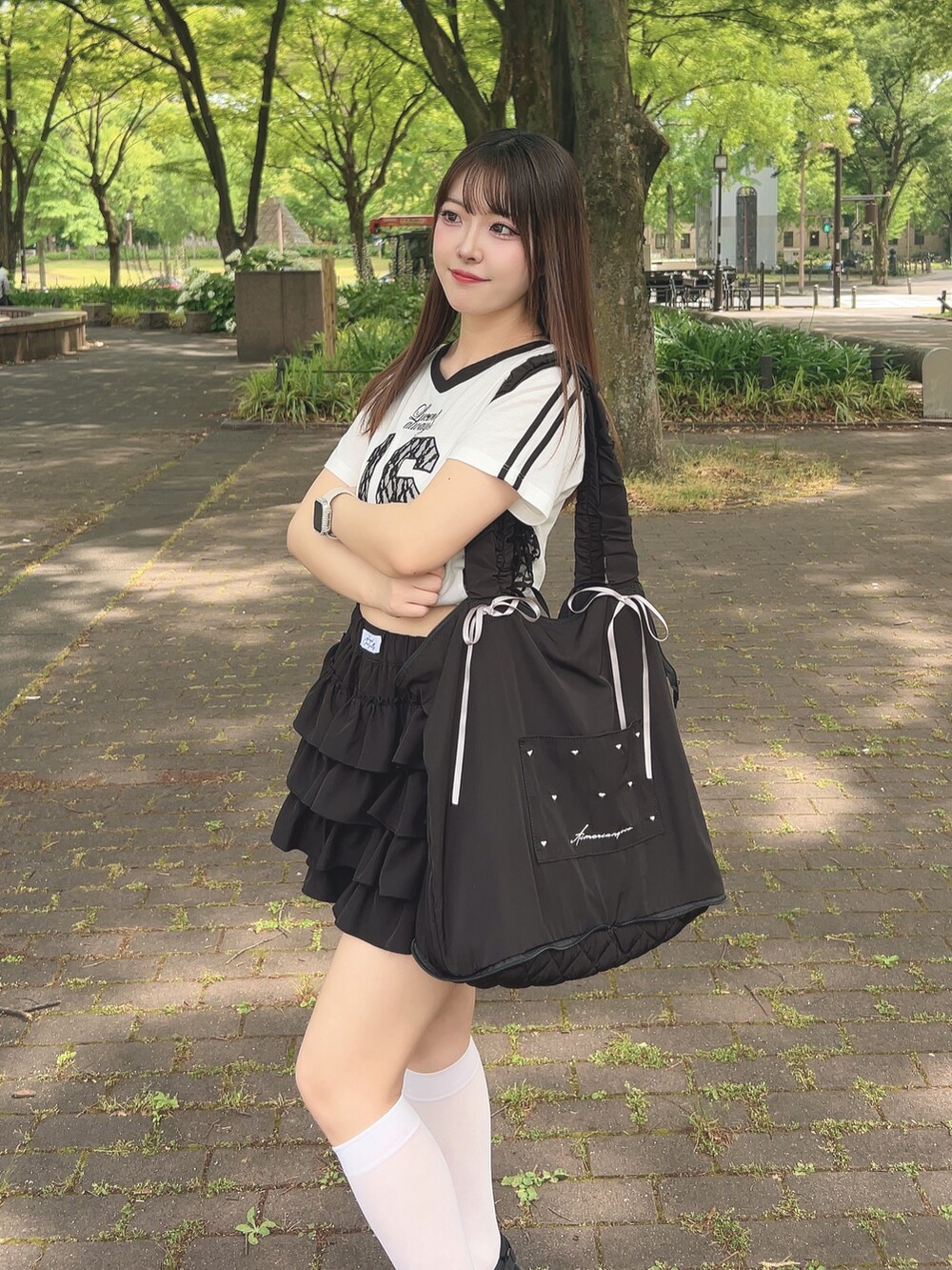 ホワイト系のTシャツ/カットソー、ブラック系のスカート、ブラック系のサンダルを着用したレディースの夏コーディネートの2枚目の写真