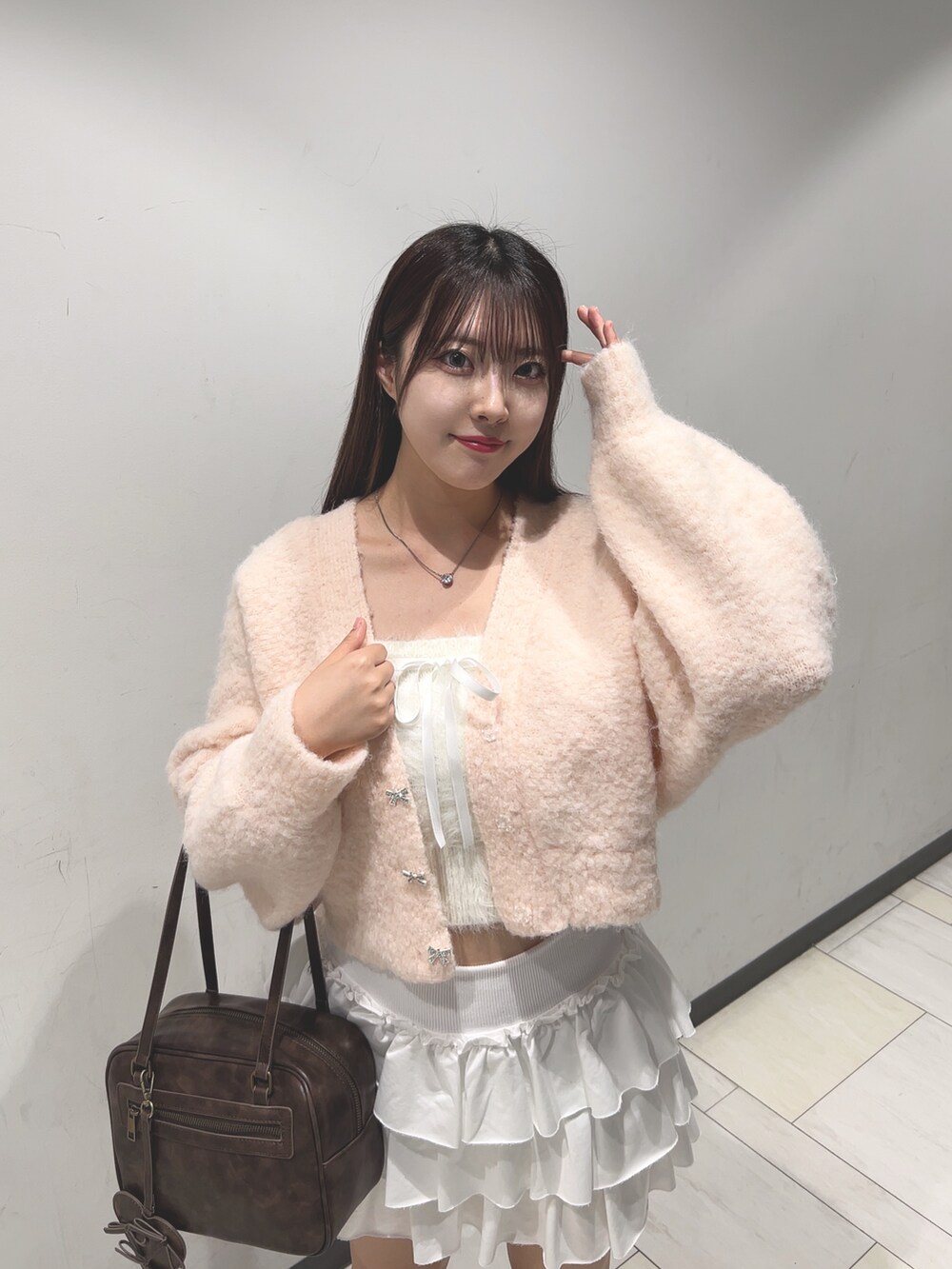 ピンク系のカーディガン/ボレロ、ホワイト系のアンサンブル、ホワイト系のスカートを着用したレディースの秋コーディネートの4枚目の写真