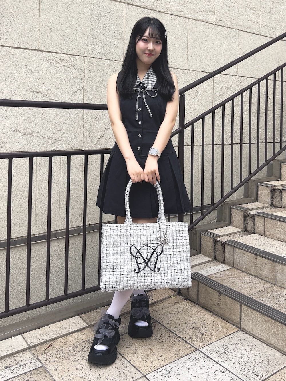 ブラック系のワンピース、ホワイト系のトートバッグ、ブラック系のサンダルを着用したレディースの夏コーディネートの4枚目の写真