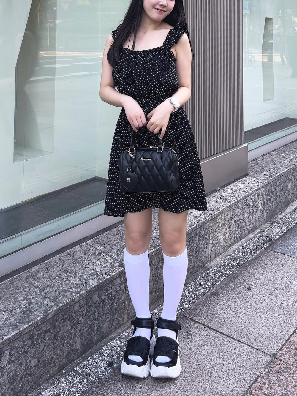 ブラック系のワンピース、ブラック系のサンダル、ブラック系のボストンバッグを着用したレディースの夏コーディネートの5枚目の写真