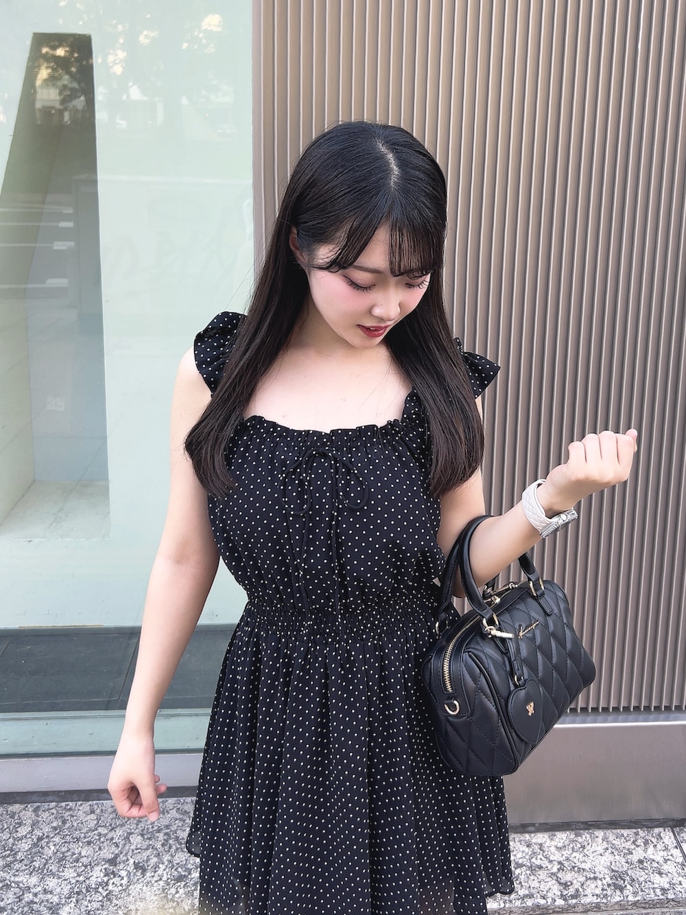 ブラック系のワンピース、ブラック系のサンダル、ブラック系のボストンバッグを着用したレディースの夏コーディネートの4枚目の写真