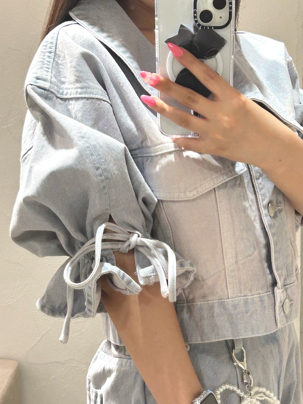 ブルー系のデニムジャケット、ブルー系のその他パンツ、シルバー系のショルダーバッグを着用したレディースの夏コーディネートの3枚目の写真