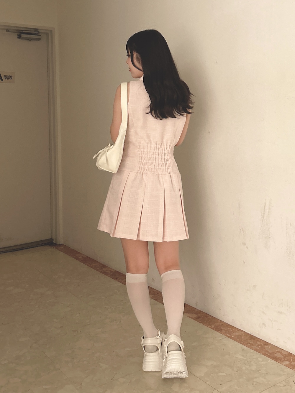 ピンク系のワンピース、ホワイト系のショルダーバッグ、ホワイト系のサンダルを着用したレディースの春コーディネートの3枚目の写真