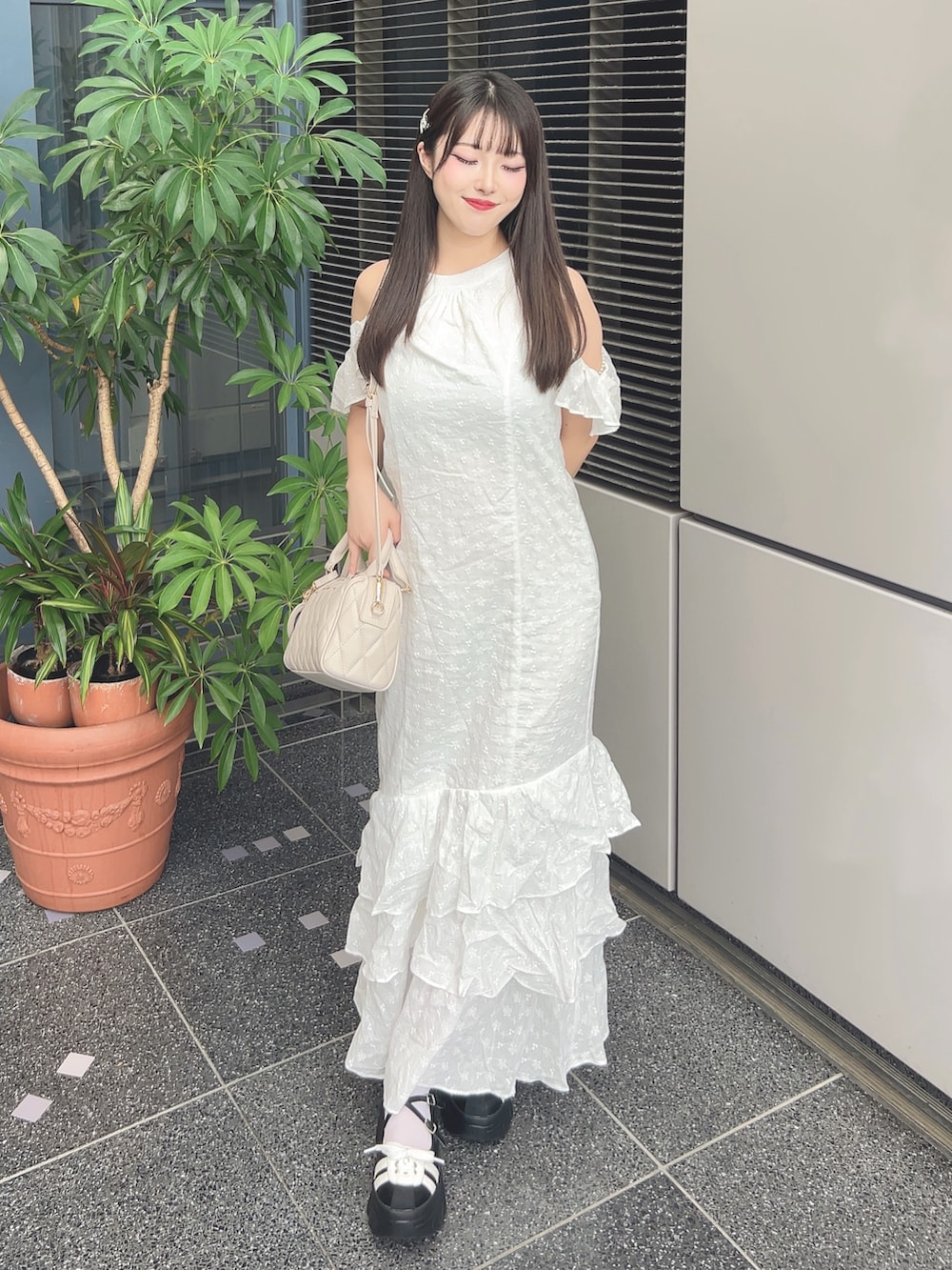 ホワイト系のワンピース、ブラック系のスニーカー、ベージュ系のボストンバッグを着用したレディースの夏コーディネートの2枚目の写真