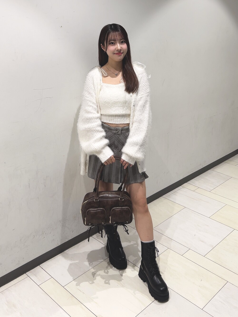 ホワイト系のアンサンブル、ホワイト系のカーディガン/ボレロ、ブラウン系のスカートを着用したレディースの秋コーディネートの5枚目の写真