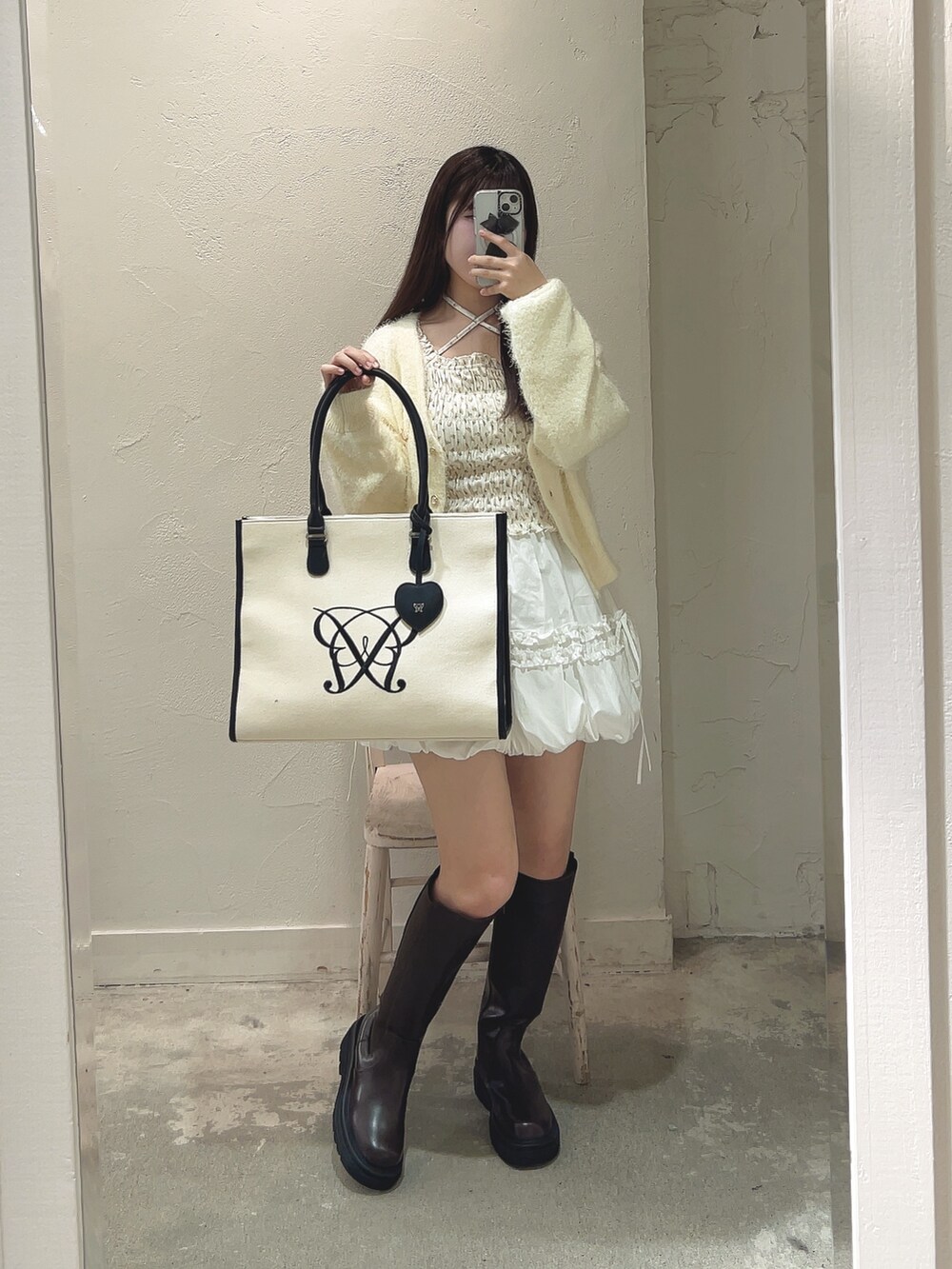 ホワイト系のTシャツ/カットソー、イエロー系のカーディガン/ボレロ、ホワイト系のトートバッグを着用したレディースの冬コーディネートの2枚目の写真
